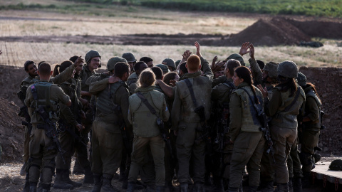 Soldados israelíes vitorean mientras se reúnen en una posición de la unidad de artillería cerca de la frontera entre Israel y la Franja de Gaza, en el lado israelí 17 de mayo de 2021.