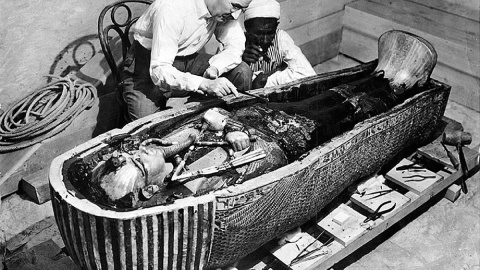 El arqueólogo británico Howard Carter examina el tercer ataúd de Tutankamón, el de oro macizo.