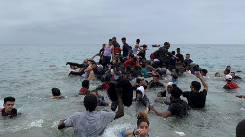 Varias personas se disponen a pasar de la playa de Fnideq (Marruecos) a Ceuta.