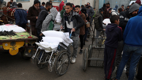 29/1/24 - Palestinos se reúnen para recibir bolsas de harina distribuidas por la UNRWA, en Rafah.