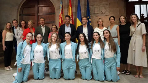 Las integrantes del equipo de gimnasia rítmica posan de rodillas junto a políticos de la Generalitat Valenciana tras ganar la medalla de bronce en el Campeonato del Mundo.