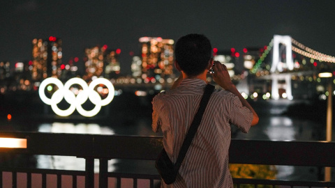 Una mujer toma una fotografía a los anillos de los Juegos Olímpicos en Tokio.