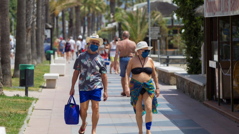 Una pareja anda por el paseo marítimo de Playamar en Málaga.