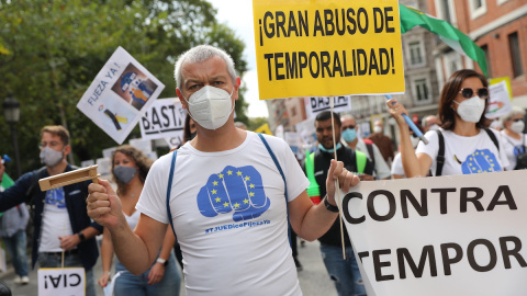 Un hombre sostiene una pancarta donde se lee "¡Gran abuso de temporalidad!", en una manifestación de trabajadores interinos para que sean declarados empleados fijos, a 25 de septiembre de 2021, en Madrid.