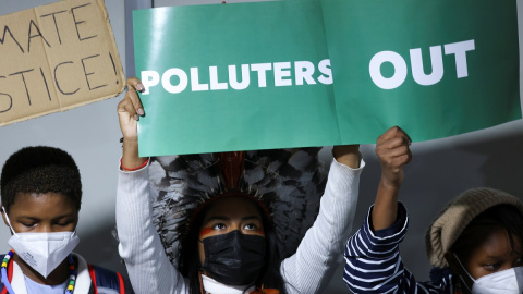 Los manifestantes protestan con pancartas en la Conferencia de las Naciones Unidas sobre el Cambio Climático de Glasgow, la COP26.