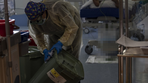 Una trabajadora de la limpieza limpia una papelera durante durante la segunda ola de coronavirus en el Hospital Universitario Ramón y Cajal, en Madrid (España).