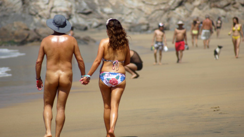 Una pareja camina por una playa nudista en Oaxaca, al suroeste de Mexico.