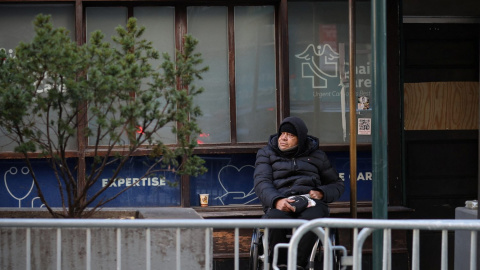 Un hombre en silla de ruedas espera a las puertas de un centro sanitario en Manhattan (Nueva York) este 8 de febrero de 2024.