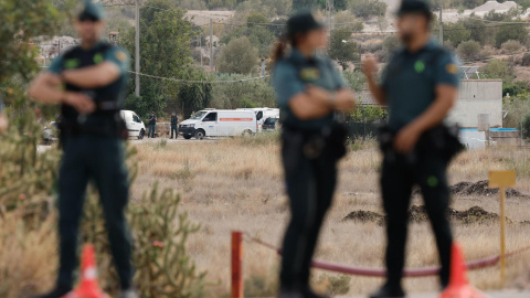 Vehículos de la Guardia Civil y de servicios fúnebres en el lugar en el que un hombre ha matado supuestamente a su mujer y a su hijo en Benaguasil.