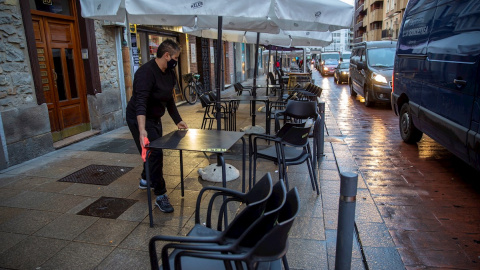 Un camarero de una tabernera de Vitoria monta la terraza de su bar.