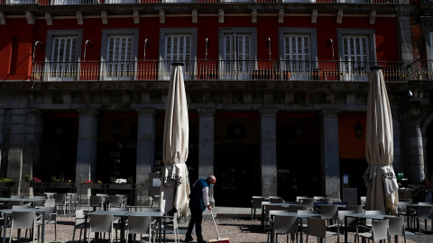 Un camarero barre en la terraza de un bar de la Plaza Mayor de Madrid. REUTERS/Sergio Perez