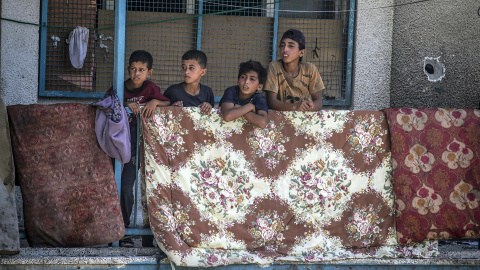 Niños palestinos desplazados en un balcón de la escuela de la UNRWA destruida por los bombardeos de Israel.