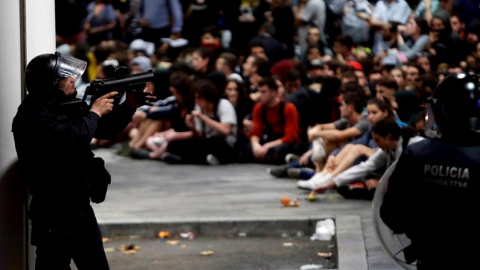 Policías antidisturbios ante los manifestantes concentrados en el aeropuerto del Prat de Barcelona tras la llamada de la plataforma Tsunami Democràtic.