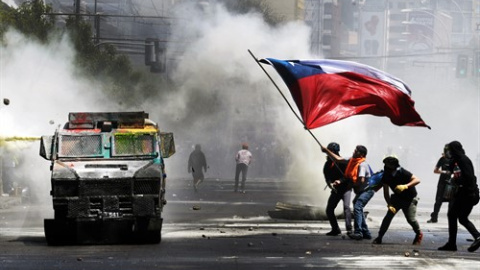 Manifestantes ondean una bandera chilena durante una protesta contra el Gobierno en las manifestaciones del 'estallido social' en el 30 de octubre de 2019.