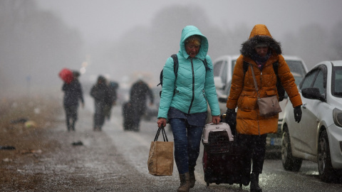 Las personas que huyen de la invasión rusa de Ucrania se dirigen hacia el cruce fronterizo de Shehyni, Polonia.