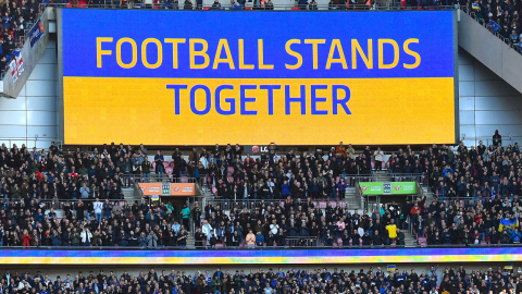 El eslogan "El fútbol se mantiene unido" se ve en una pantalla gigante antes de la final de la Copa Carabao inglesa entre el Chelsea FC y el Liverpool FC en Wembley en Londres, Gran Bretaña, el 27 de febrero de 2022.