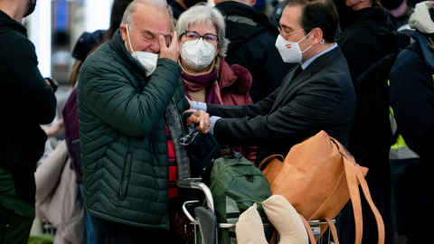 El ministro de Asuntos Exteriores, Unión Europea y Cooperación, José Manuel Albares (d), recibe a un español repatriado, que llega emocionado, al Aeropuerto Adolfo Suárez Madrid Barajas