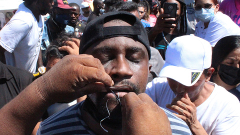 Migrantes se cosen hoy la boca mientras participan en una manifestación en la ciudad de Tapachula, estado de Chiapas (México).