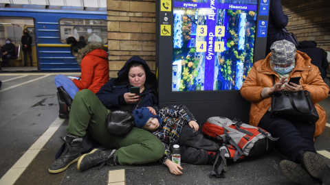 Dos mujeres, junto a un niño recostado, se refugian en el metro de Kiev el pasado 24 de febrero tras al ataque masivo de Rusia a Ucrania.