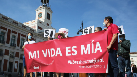 Un grupo de personas se reúne sosteniendo pancartas y carteles durante la concentración de la asociación Derecho a Morir Dignamente (DMD) en la Puerta del Sol, a 25 de junio de 2021, en Madrid, (España)