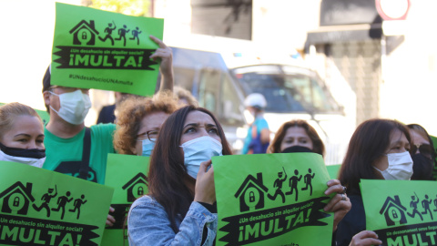 Una activista de la PAH cridant a l'Ajuntament de Barcelona amb una furgoneta dels Mossos al darrere. 11 de novembre del 2020.