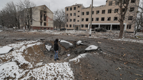 Un hombre se para dentro del cráter realizado por un proyectil durante el bombardeo nocturno de Rusia a una instalación militar ucraniana en Brovary, cerca de Kiev, Ucrania, este 1 de marzo de Ucrania.