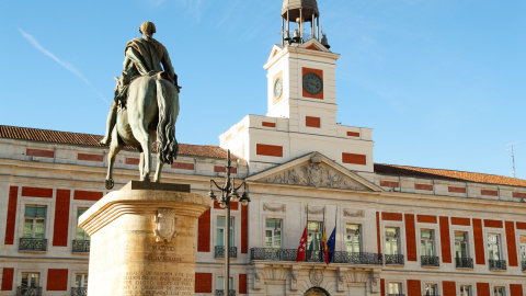 Las banderas madrileña, española y de la UE ondean a media asta en la fachada de la Real Casa de Correos, sede del Gobierno regional, como muestra de luto por el fallecimiento de la reina Isabel II de Inglaterra ceca de la estatua de Carlos III este vie