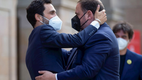 21/05/2021.- El presidente de ERC, Oriol Junqueras (d) - con un permiso penitenciario- saluda al expresident del Parlament, Roger Torrent (i) antes del comienzo de la segunda jornada del debate de investidura celebrada en el Parlament este viernes. EFE/En