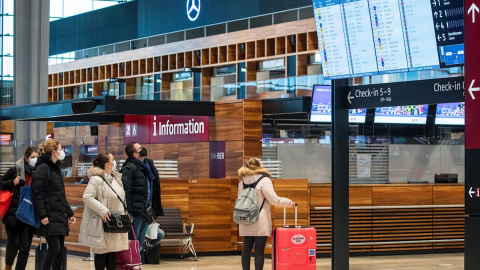 Pasajeros observan el panel de vuelos en el aeropuerto de Berlín. Alemania ha suspendido los vuelos a Reino Unido por la nueva cepa del coronavirus.