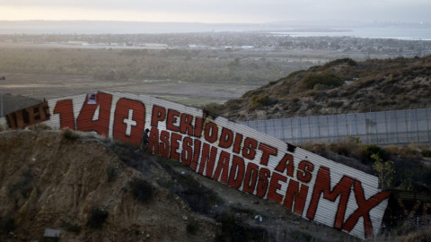 Una pintura que dice "140 periodistas asesinados en MX" en una sección de la valla fronteriza entre EE. UU. y México en Tijuana, en el estado de Baja California, México, en 2018