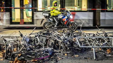 Un policía observa parte de los daños causado tras una protesta en la ciudad portuaria de Róterdam contra las restricciones aplicadas por el Gobierno para frenar los contagios en Países Bajos.