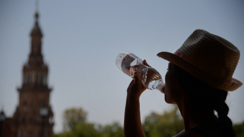 Una mujer bebe agua en Sevilla durante la ola de calor de junio de 2019.