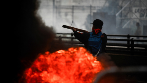 Un manifestante sostiene un trozo de madera mientras asiste a una protesta cerca del Congreso Nacional, a 12 de junio de 2024.