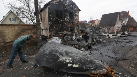 Un hombre observa los restos de un avión militar derribado durante la noche del 25 de febrero de 2022 en Kiev, Ucrania.