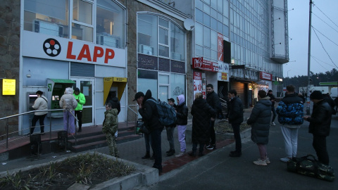 La gente hace cola en un cajero automático (ATM) en una sucursal de un banco en Kiev, el 24 de febrero de 2022, en Kiev, Ucrania