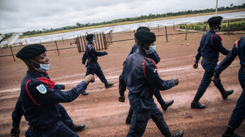 Agentes de la Policía congoleña desfilan en la pista del aeropuerto de Gbadolite, en el norte de la República Democrática del Congo, para la repatriación de refugiados centroafricanos a Bangui, el 15 de noviembre de 2021.