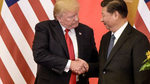 Donald Trump, a la izquierda, estrechando la mano del líder chino, Xi Jinping - FRED DUFOUR/AFP