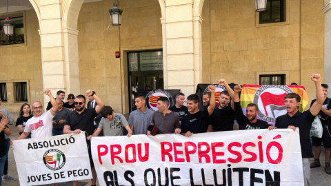 Algunos de los antifascistas acusados posan con una pancarta a la salida de un juicio en la Audiencia Provincial de Alicante, a 13 de junio de 2024