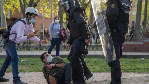 El periodista Guillermo Martínez, en el suelo junto a dos policías antidisturbios, el 7 de abril de 2021, día del mitin de Vox en Vallecas