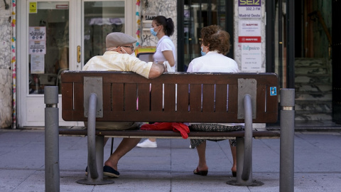 Una pareja de ancianos con mascarilla sentada en un banco, el 27 de julio de 2021, en Madrid, (España).