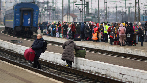 Refugiados ucranianos cruzan las vías del tren en la estación de Lviv.