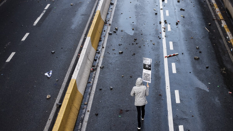 Un manifestante con un cartel que dice 'Respeta mi existencia o espera mi resistencia' participa en una manifestación contra las medidas restrictivas en Bruselas el 21 de noviembre de 2021.