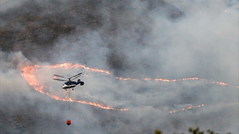 Helicóptero contra incendio intentando apagar el fuego de la Sierra Bermeja, visto desde el cerro de la Silla de los Huesos, a 13 de septiembre 2021 en Casares (Málaga) Andalucía