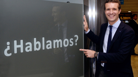 El candidato a la Presidencia del PP Pablo Casado posa junto una publicidad de un establecimiento comercial, en el que se puede leer “¿Hablamos?”. EFE/Nacho Gallego