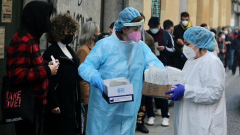 10/03/2022. Dos sanitarias recogen test de covid-19 de las personas que hacen cola en un Centro de Salud, a 21/12/2021.