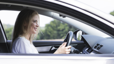 Una mujer conduce un coche.