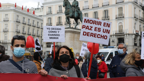 Una mujer con un cartel en el que se lee: `Morir en paz es un derecho´ durante una concentración de Derecho a Morir Dignamente en la Puerta del Sol, en Madrid (España), a 18 de marzo de 2021.