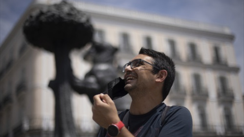 Un hombre se quita la mascarilla en la Puerta del Sol, a 18 de junio de 2021, en Madrid (España).