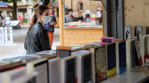 Una mujer con mascarilla este sabado en la feria del libro de Oviedo.