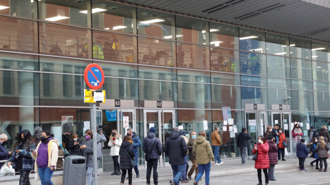 Diversas personas hacen cola a las puertas del recinto Wizink Center donde se administran las vacunas frente a la covid-19.